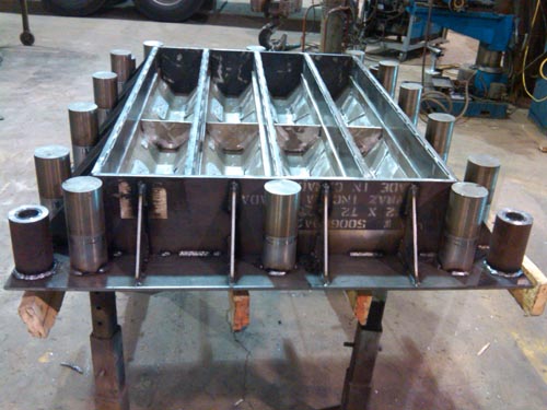 Professional industrial welder welding metal parts in metalworking factory